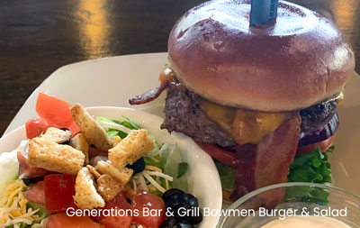 A Generations Bar Grill Sherwood Bowmen Burger served on a plate with a side salad.
