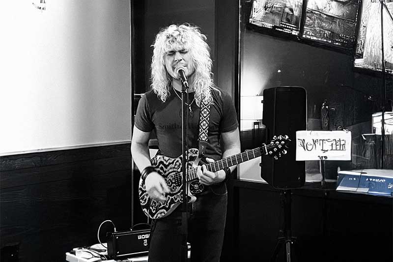 Sammy D performs on stage at Generations Bar & Grill Sherwood, playing guitar indoors.